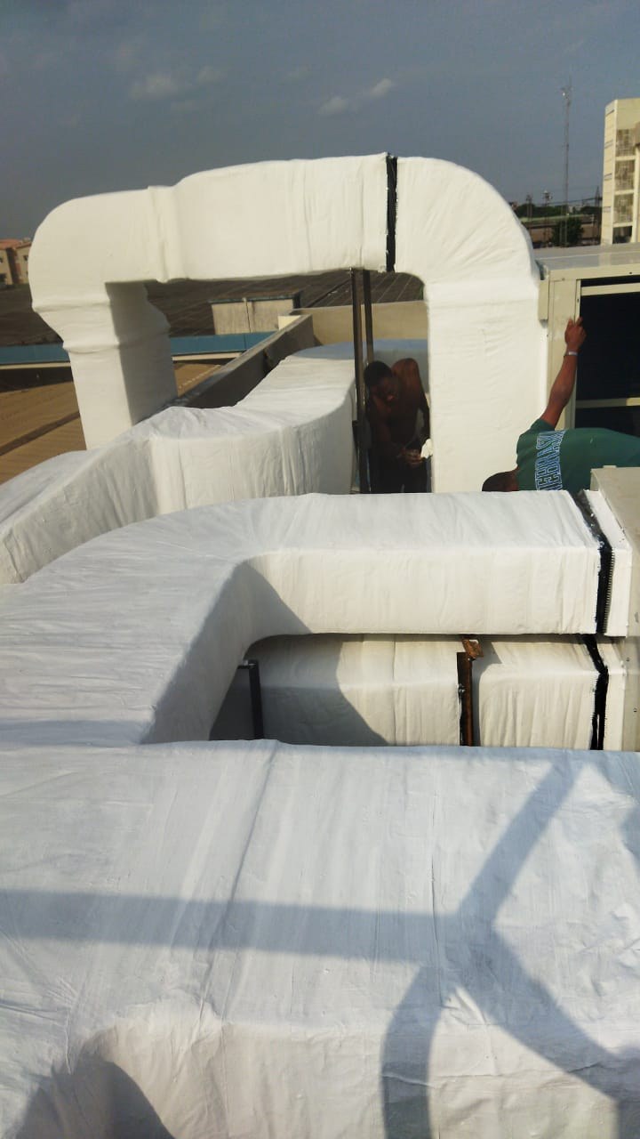 Insulated rooftop ductwork at Comart Nigeria Ltd with technicians at work