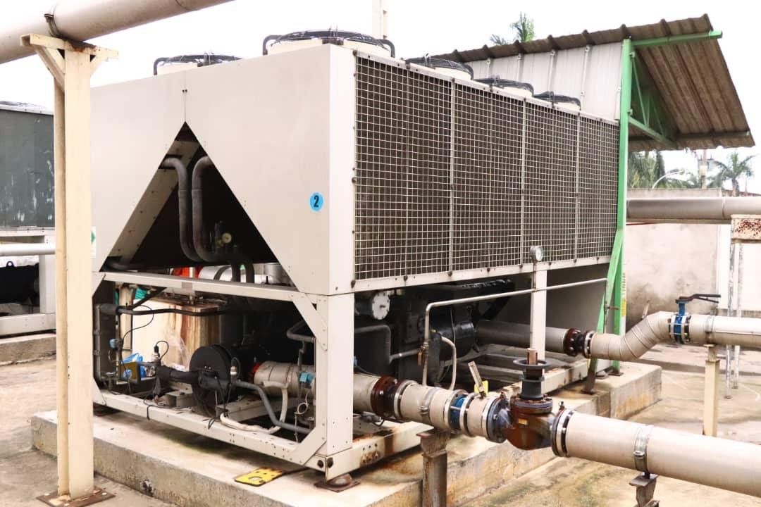 Air-cooled chiller on a concrete plinth with chilled-water pipework at Comart Nigeria Ltd