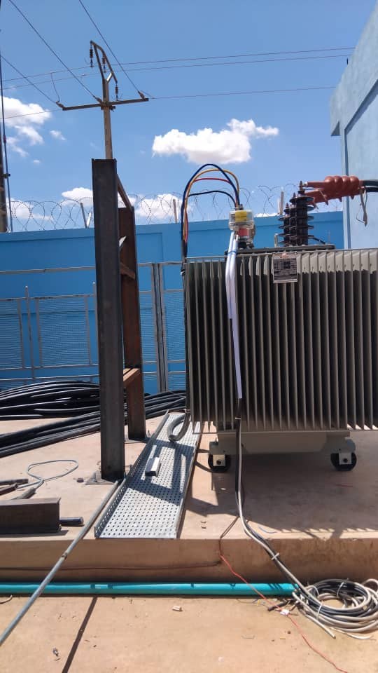 Transformer on its plinth beside a cable tray run, Burkina Faso