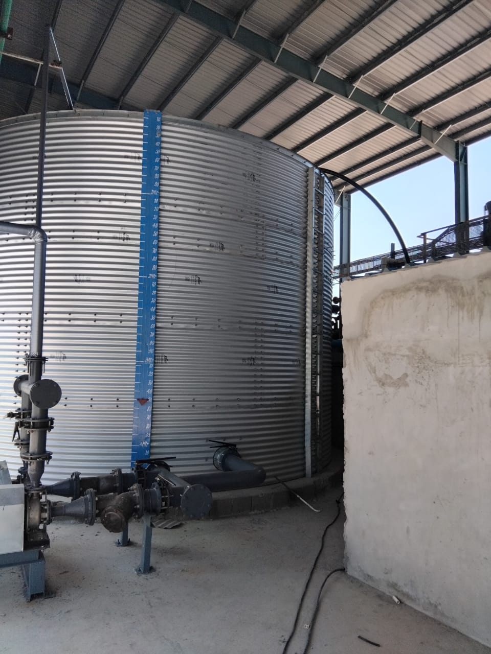 Corrugated steel tank with level gauge and pump pipework at the ETP installation, Burkina Faso
