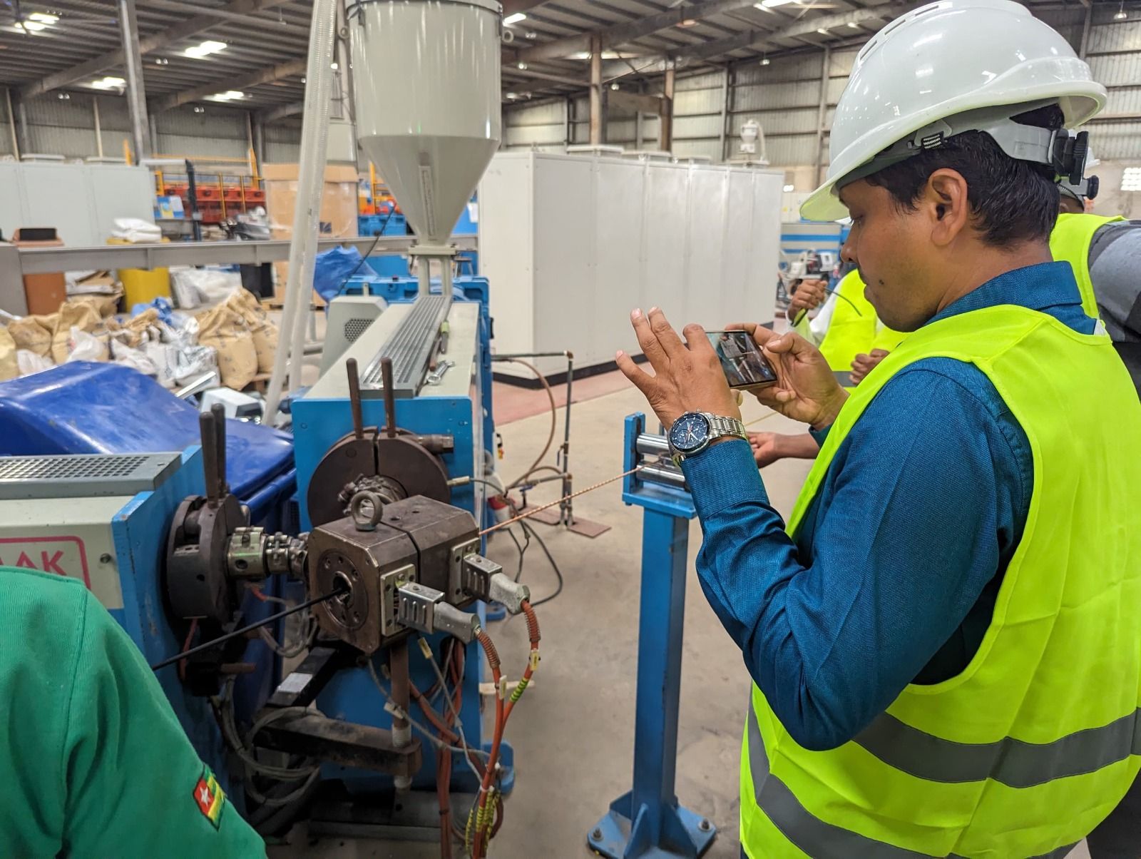 Maydok Ventures engineer documenting cable production equipment at a factory